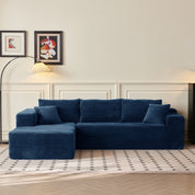 Blue sectional sofa in a living room with framed art on the wall.