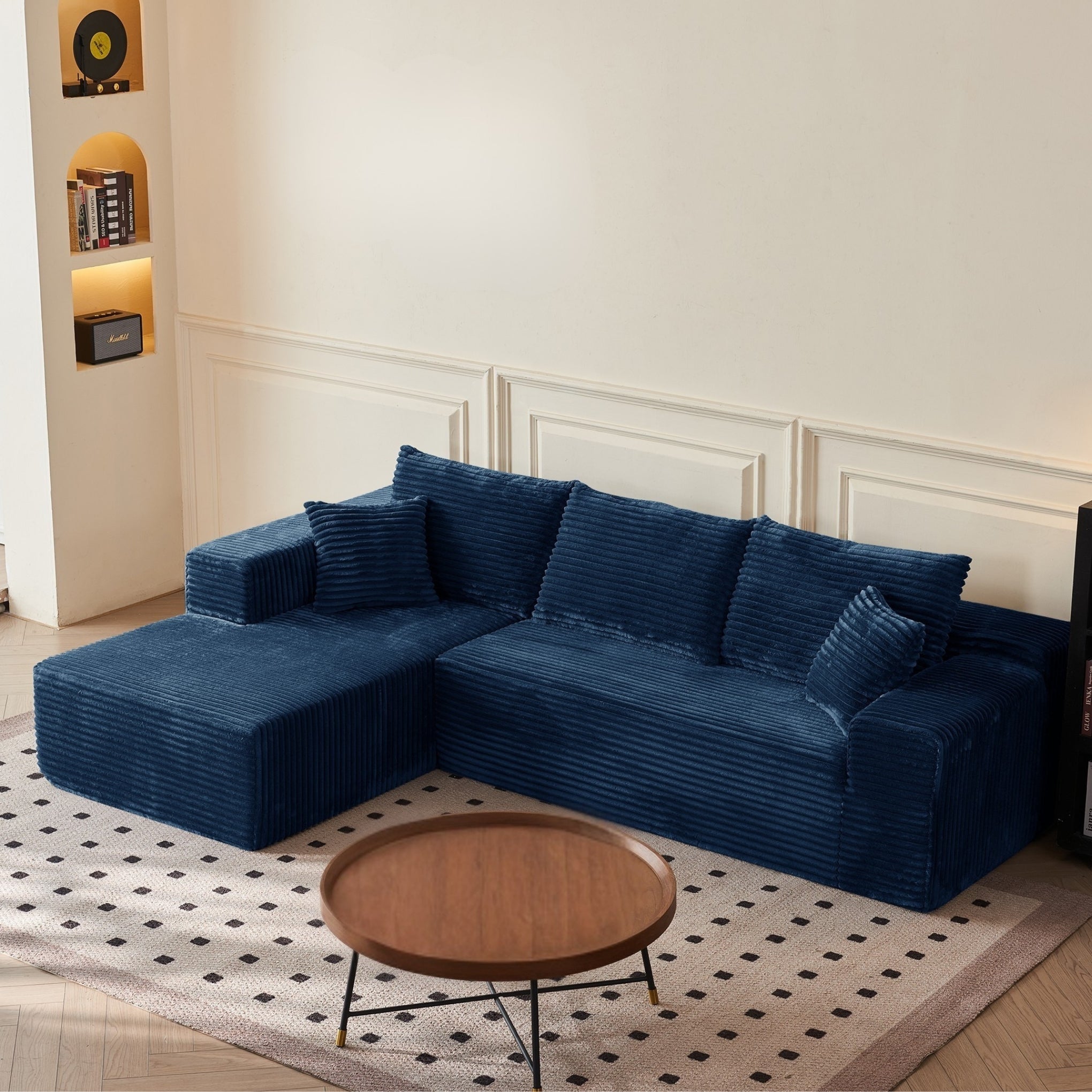 Blue sectional sofa in a living room with a round wooden coffee table.